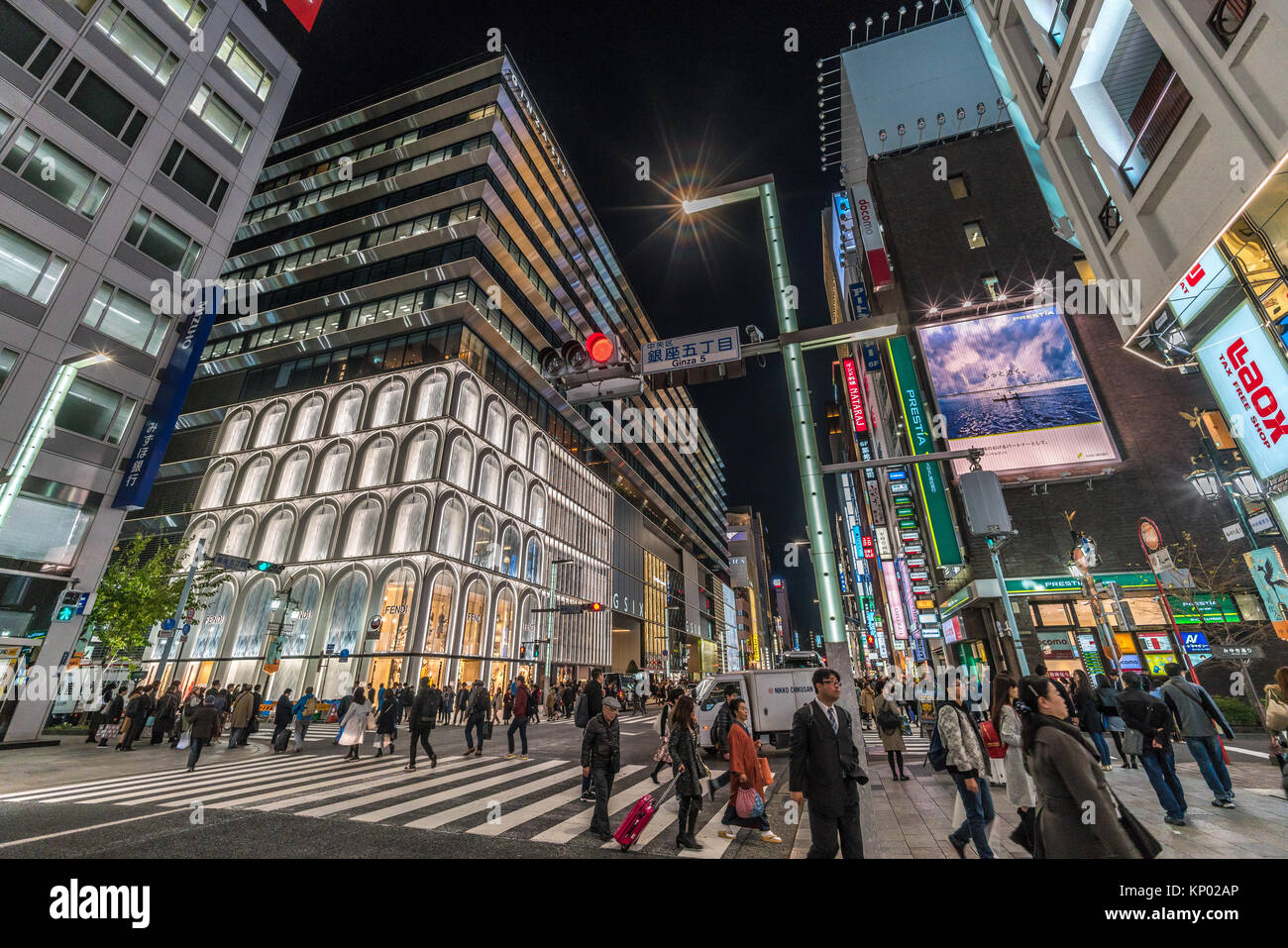 Ginza, Tokyo - December 2017 : Illuminated billboards in crowded Chuo dori street at Ginza luxurious shopping District by night. Stock Photo