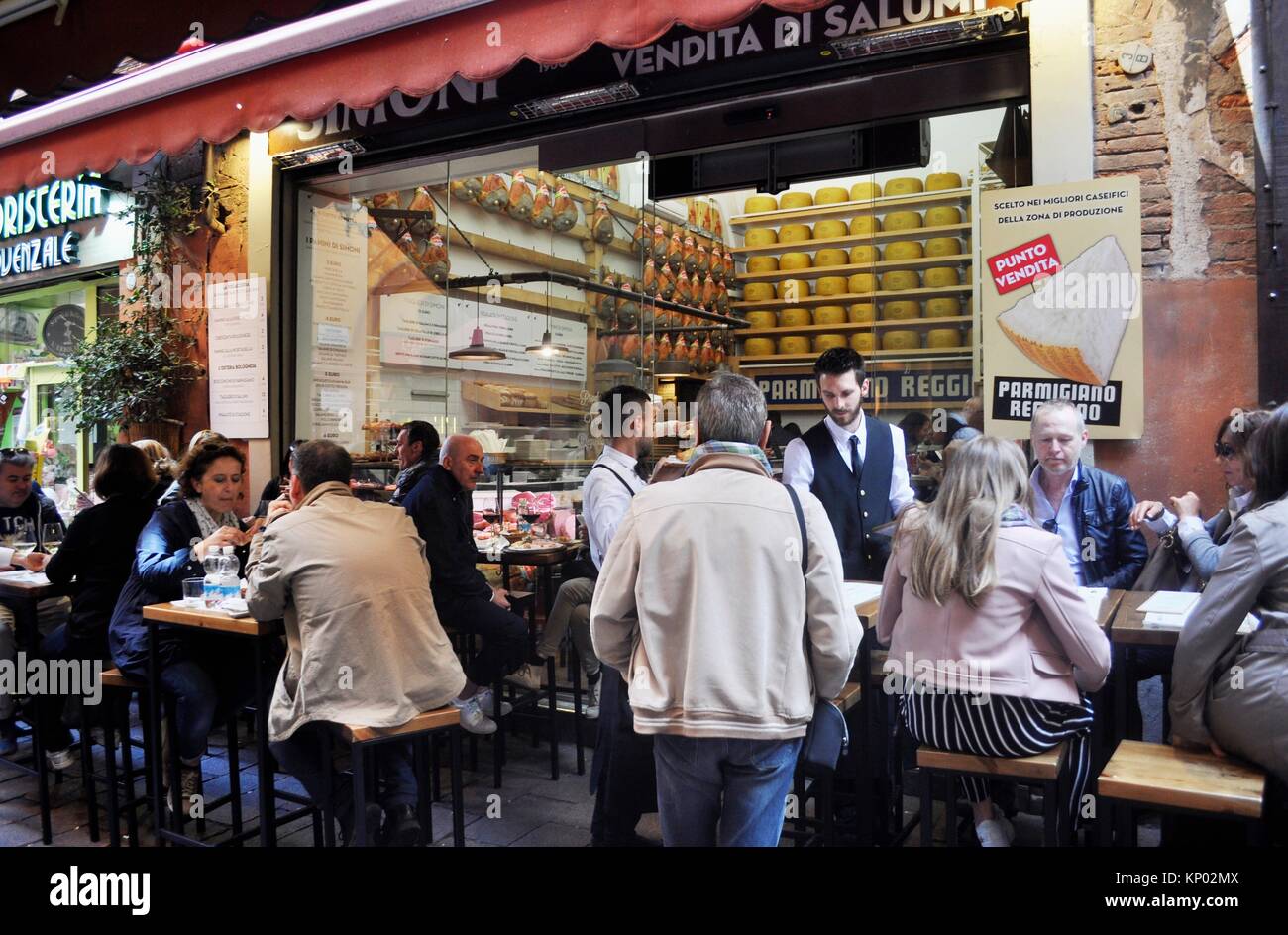 Bologna, Italy: tourists eating at a cold cuts and Parmesan cheese along via Pescherie Vecchie Stock Photo