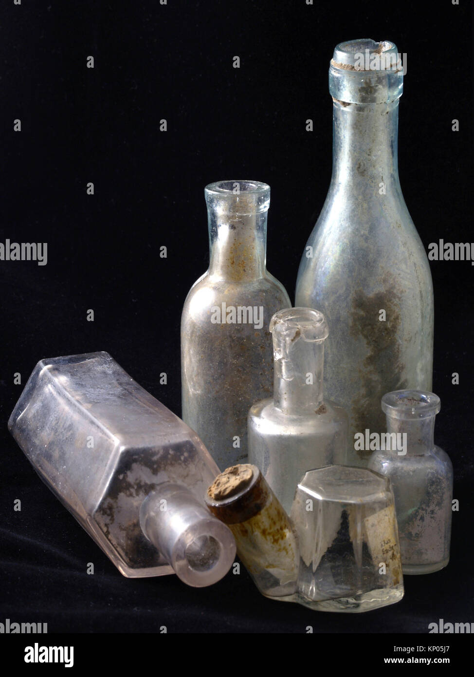 Old antique glass transparent bottles on black background, modern