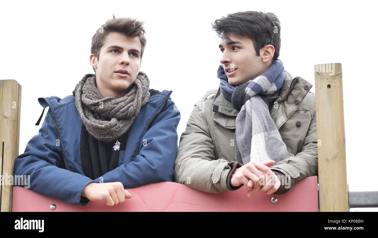 From below view of young men in winter clothing talking while chilling ...