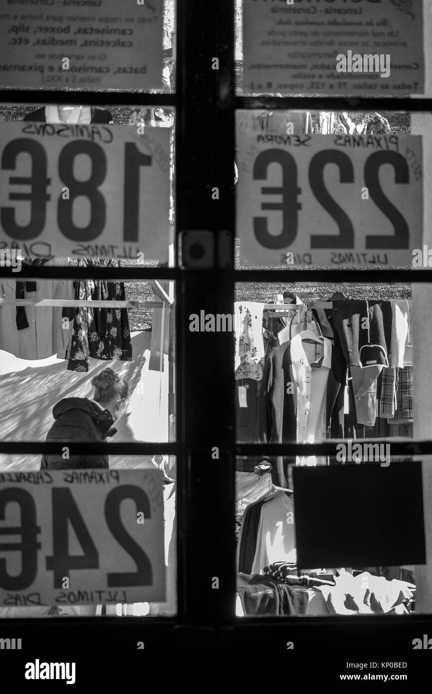 Street stalls and clothing prices in Euros, seen through a window, for