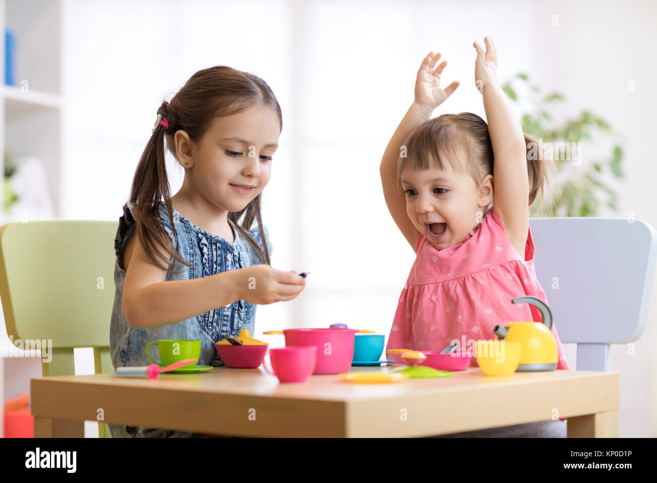 Children playing with plastic tableware Stock Photo