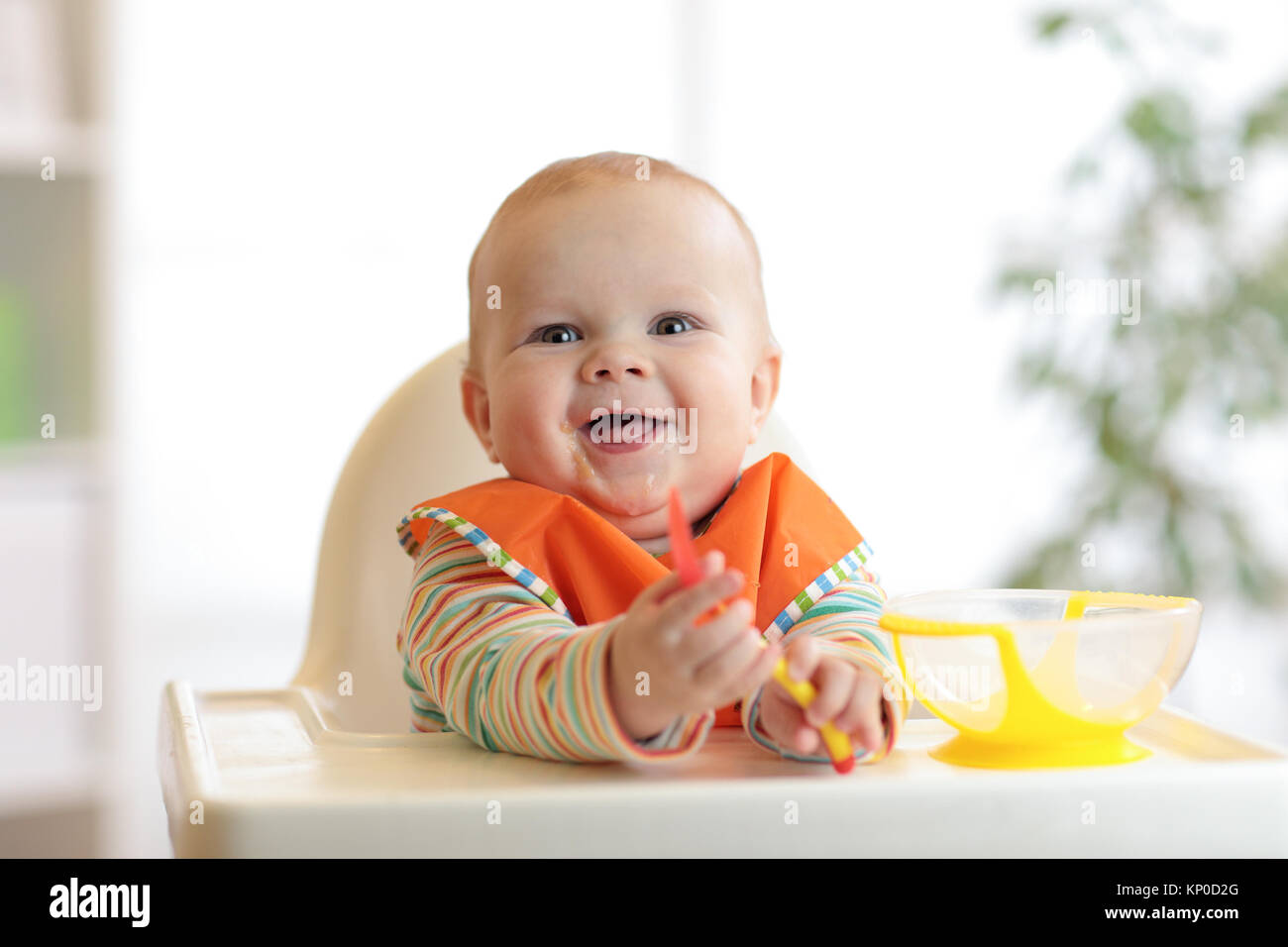 happy baby boy with spoon at table Stock Photo