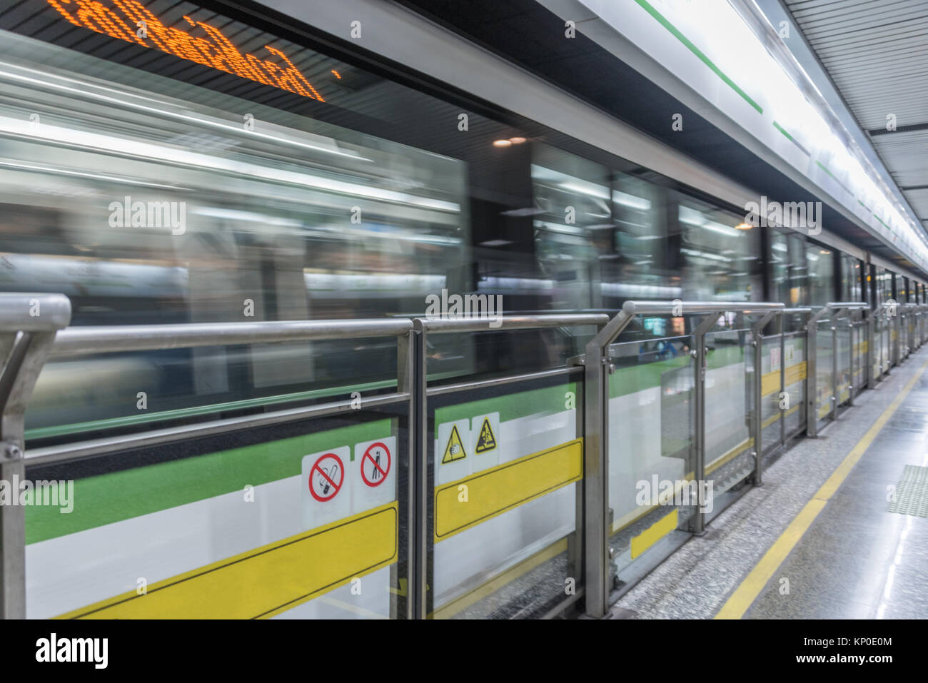 Blurred view of train leaving platform in city of China. Stock Photo