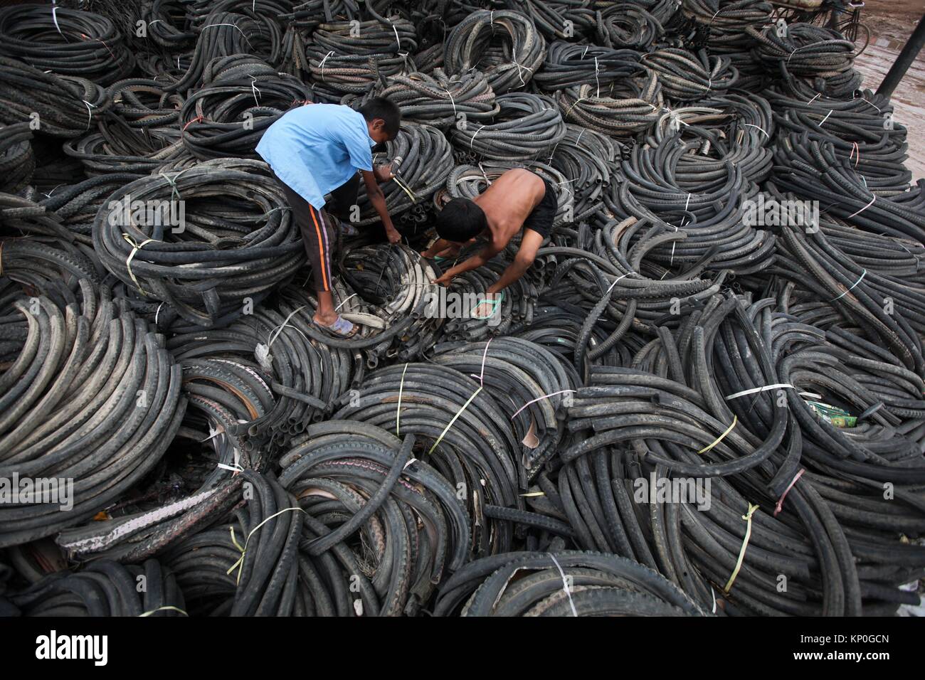 Bangladeshi child laborers handle pieces of old tyres to be recycled in Dhaka. The recycling industry in the Bangladeshi capital plays an important Stock Photo