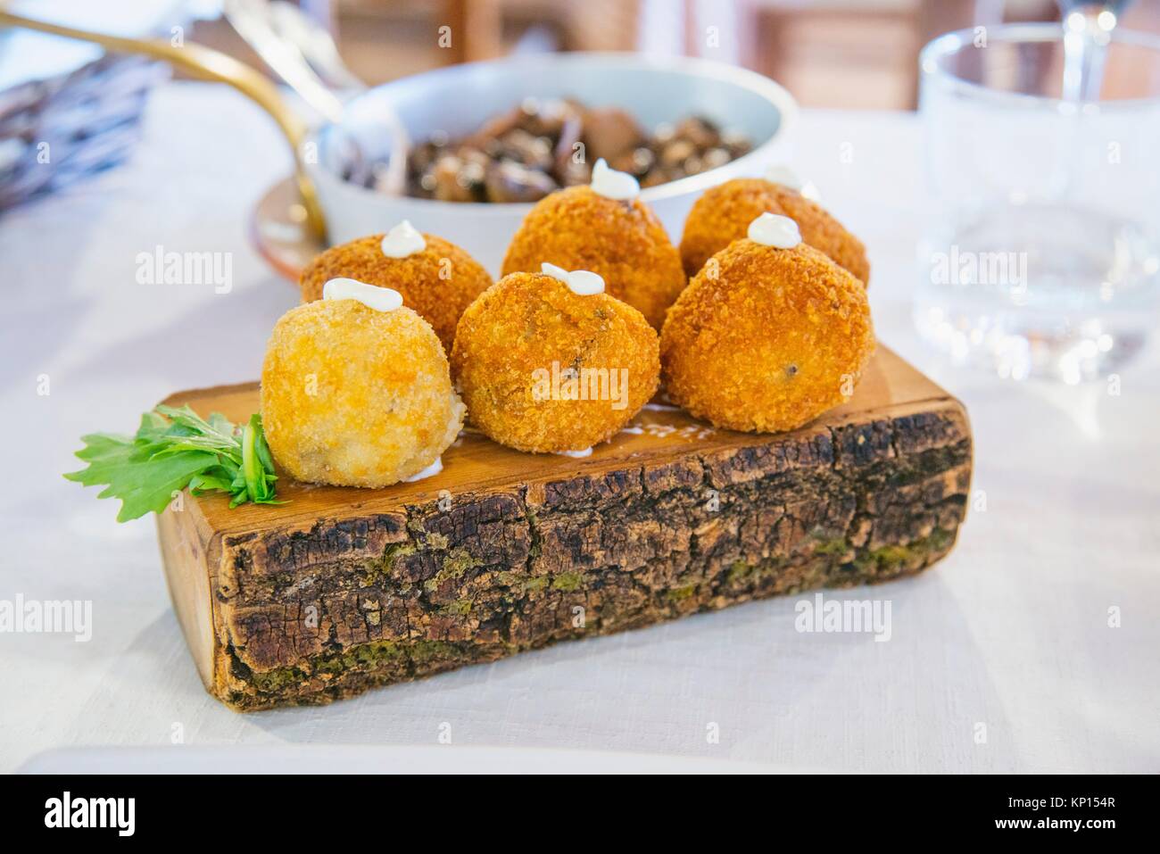 Assorted croquettes served on tree trunk. Stock Photo