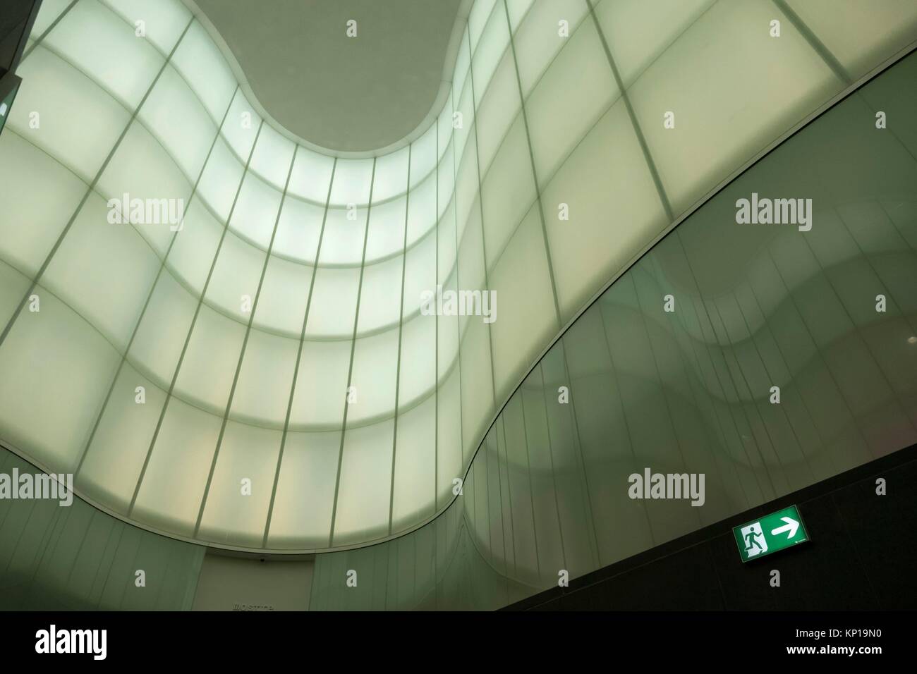 Green and grey undulating wave walls and window reflections, Milan, Italy Stock Photo