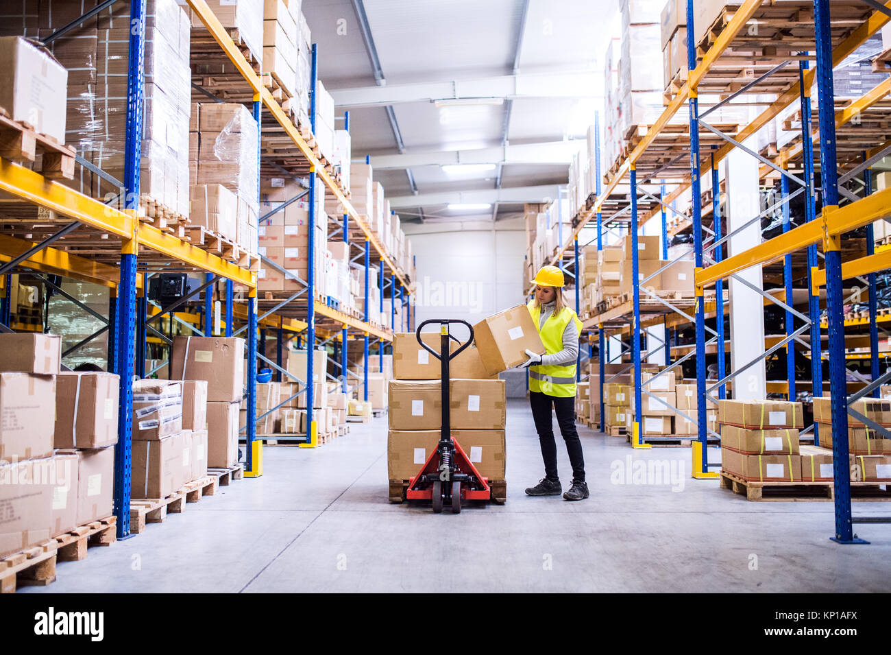 Female warehouse worker loading or unloading boxes Stock Photo - Alamy