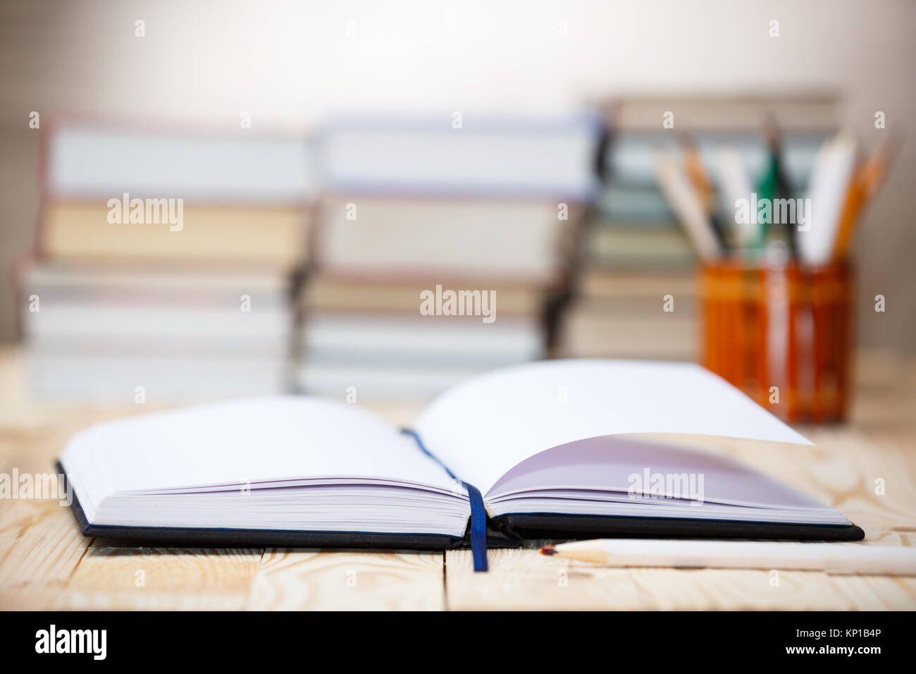 Open book on wood desk with blurred focus for background. Stock Photo