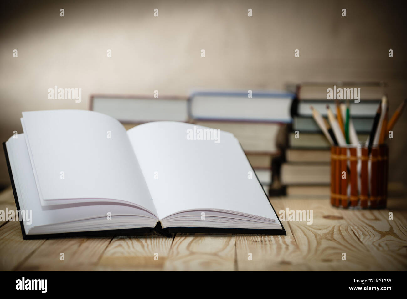 Open book on wood desk with blurred focus for background. Stock Photo