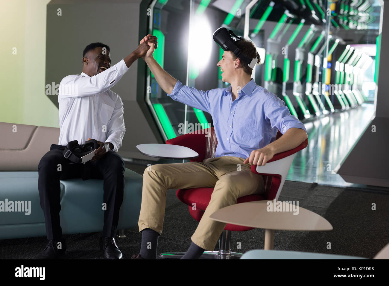 Male executives giving high five to each other in office Stock Photo ...