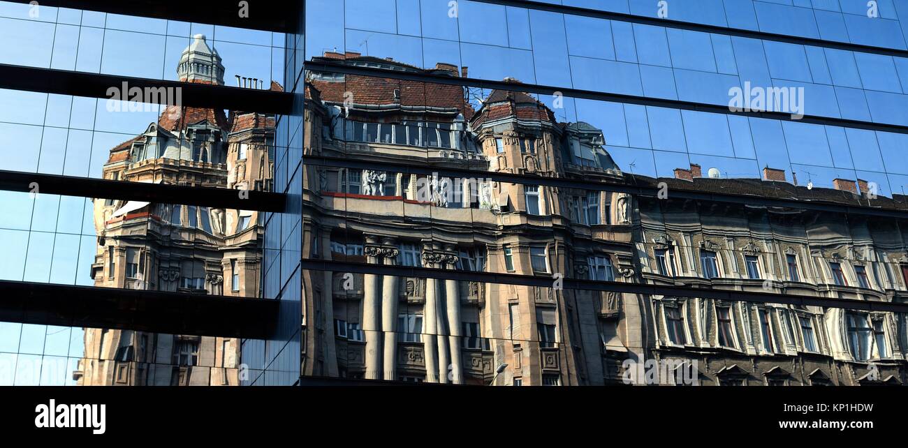Panoramic architecture contrast old house reflection in glass windows of a new modern building in Budapest, Hungary Stock Photo