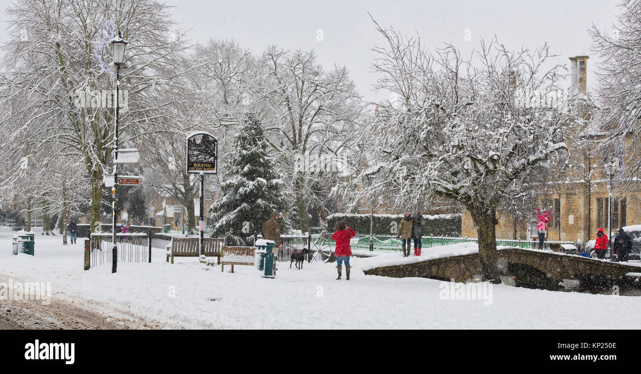 Falling snow covering the Christmas tree in Bourton on the Water, Cotswolds, Gloucestershire, England. Panoramic Stock Photo