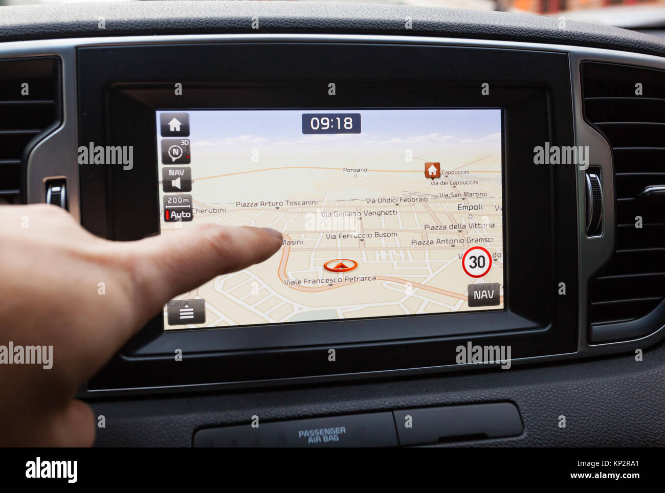 GPS navigation panel on dashboard inside a car. Finger pointing on destination point. Stock Photo