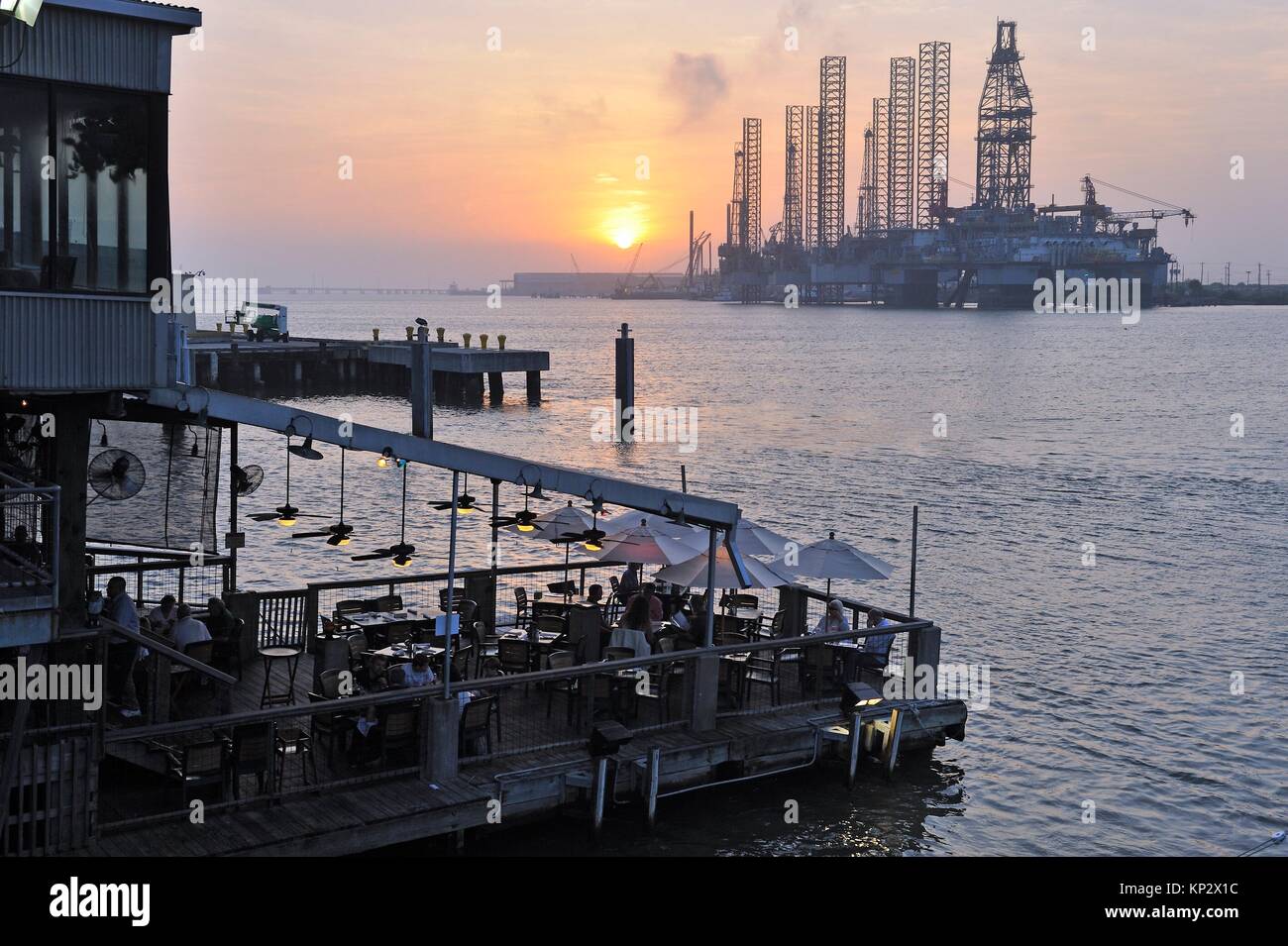 terrace of the Fisherman´s Wharf restaurant with oil platform in the background at sunset, Port of Galveston, Galveston island, Gulf of Mexico, Stock Photo