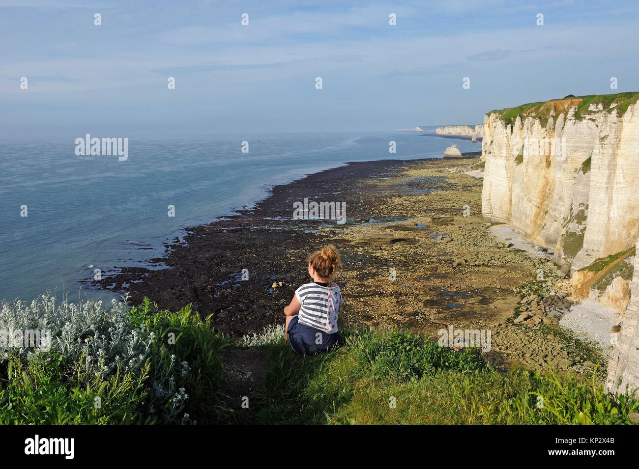 young girl watching ocean sitting on the top of the cliffs of Etretat, Seine Maritime department, Normandie region, France, Europe. Stock Photo