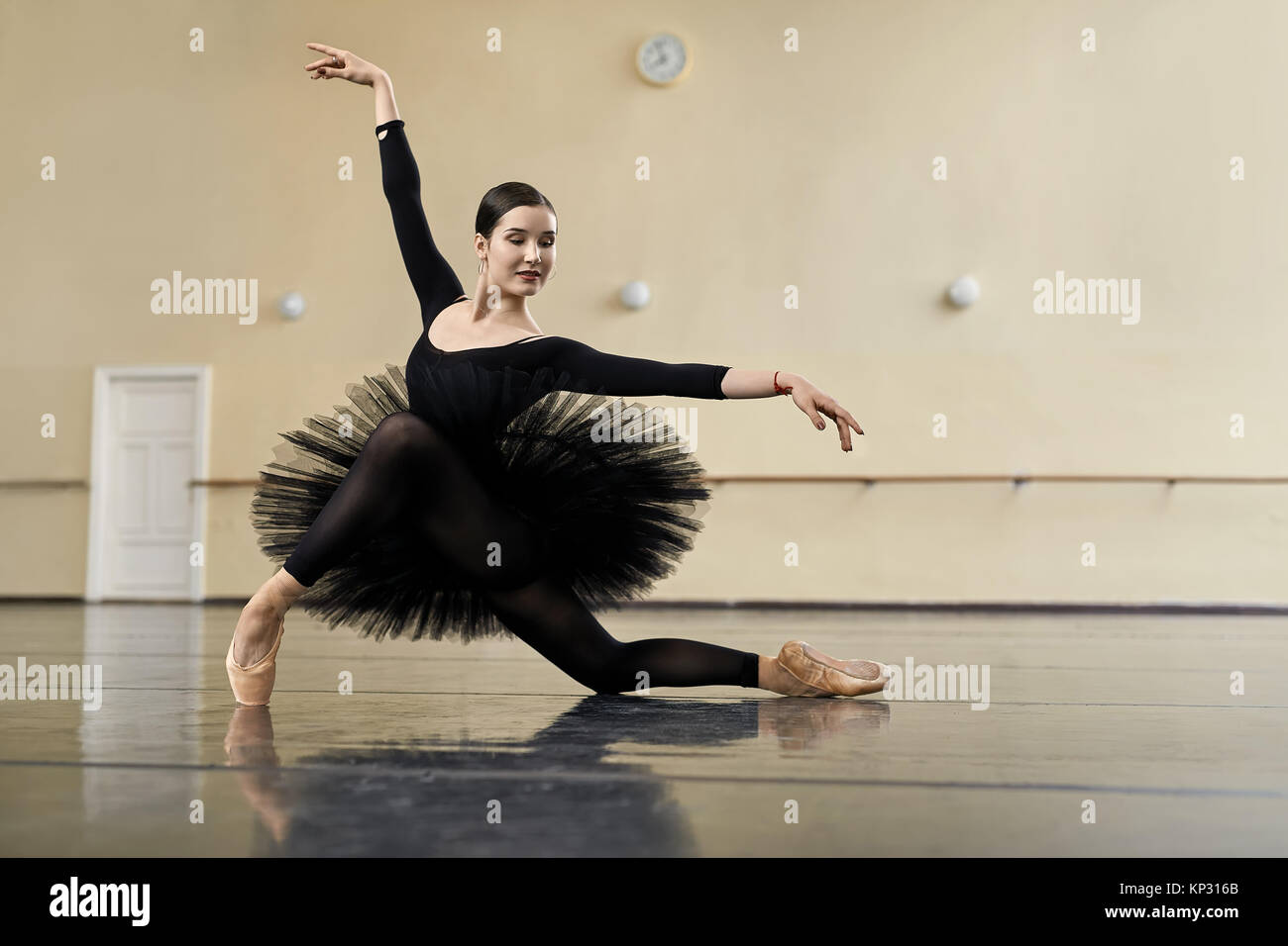 Attractive ballerina posing in the dance hall. Her arms outstretches Stock  Photo - Alamy