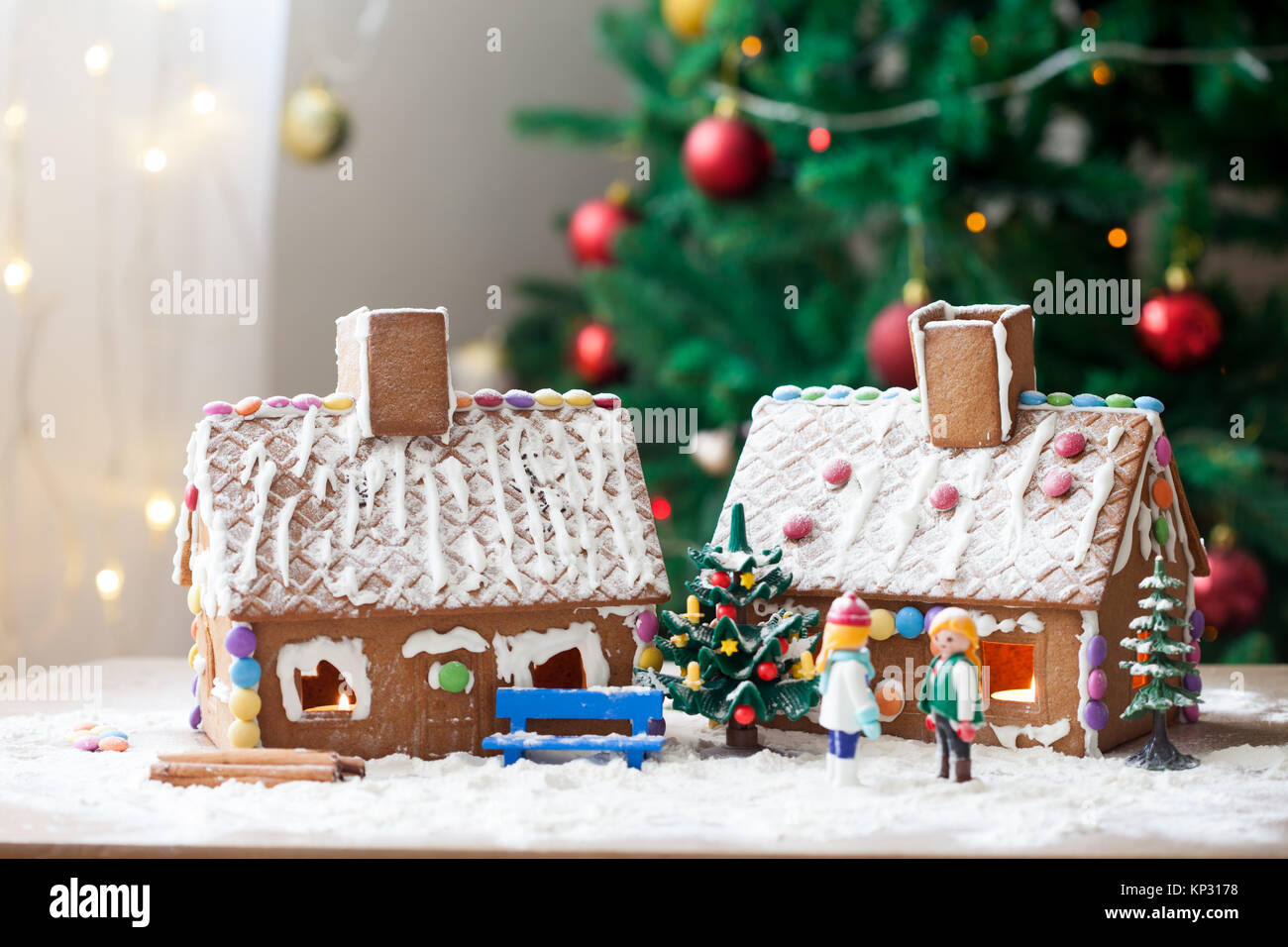 Two gingerbread houses, tree and people sitting on a bench, winter ...