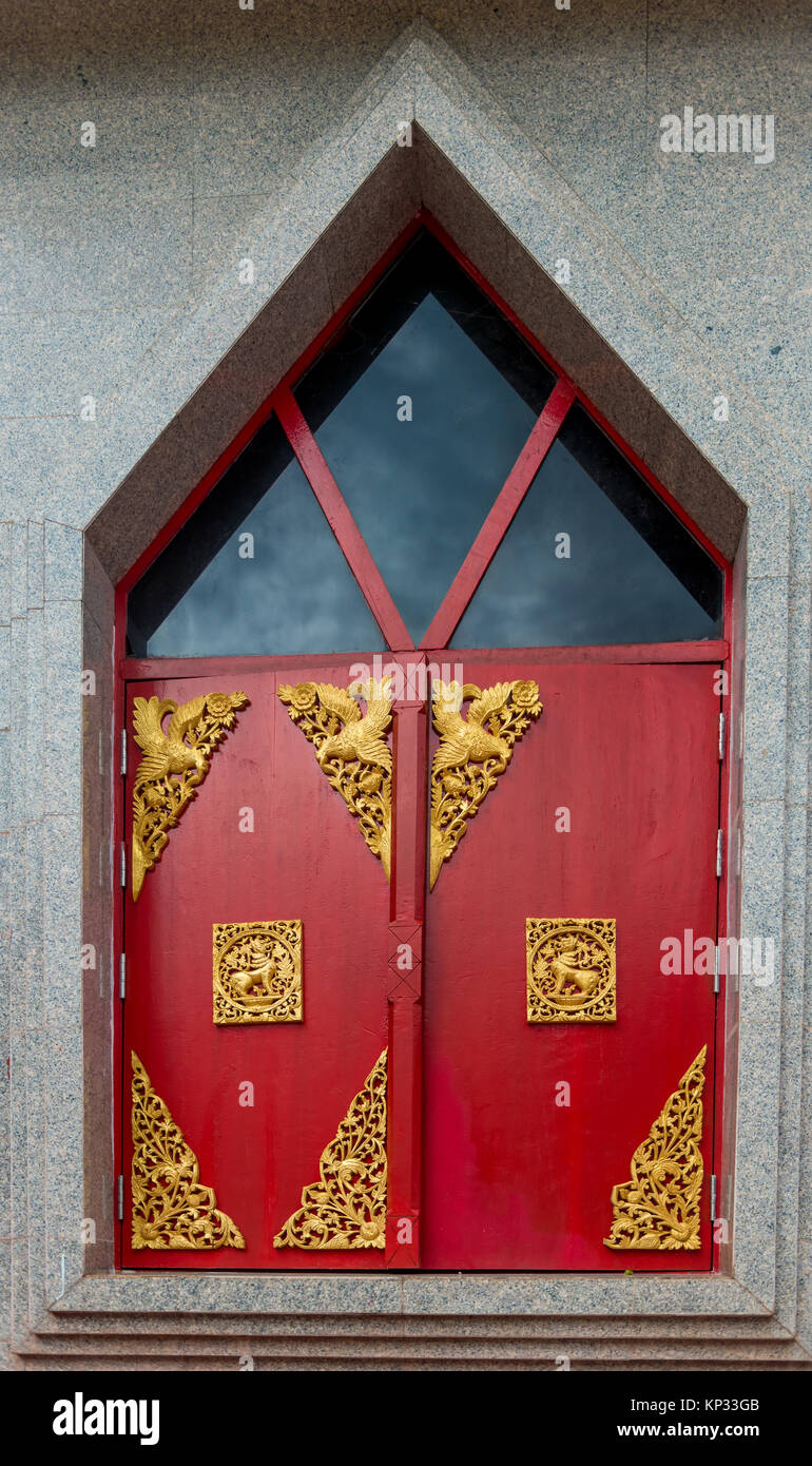 red window shutters decorated with gold ornaments on a temple in ...