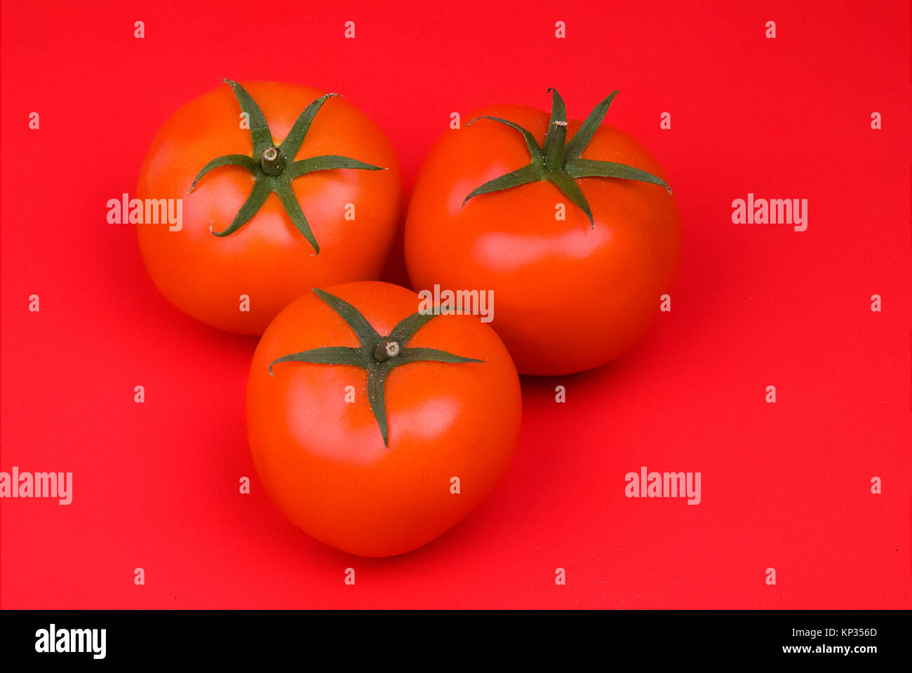 Group of red tomatos on red background Stock Photo - Alamy