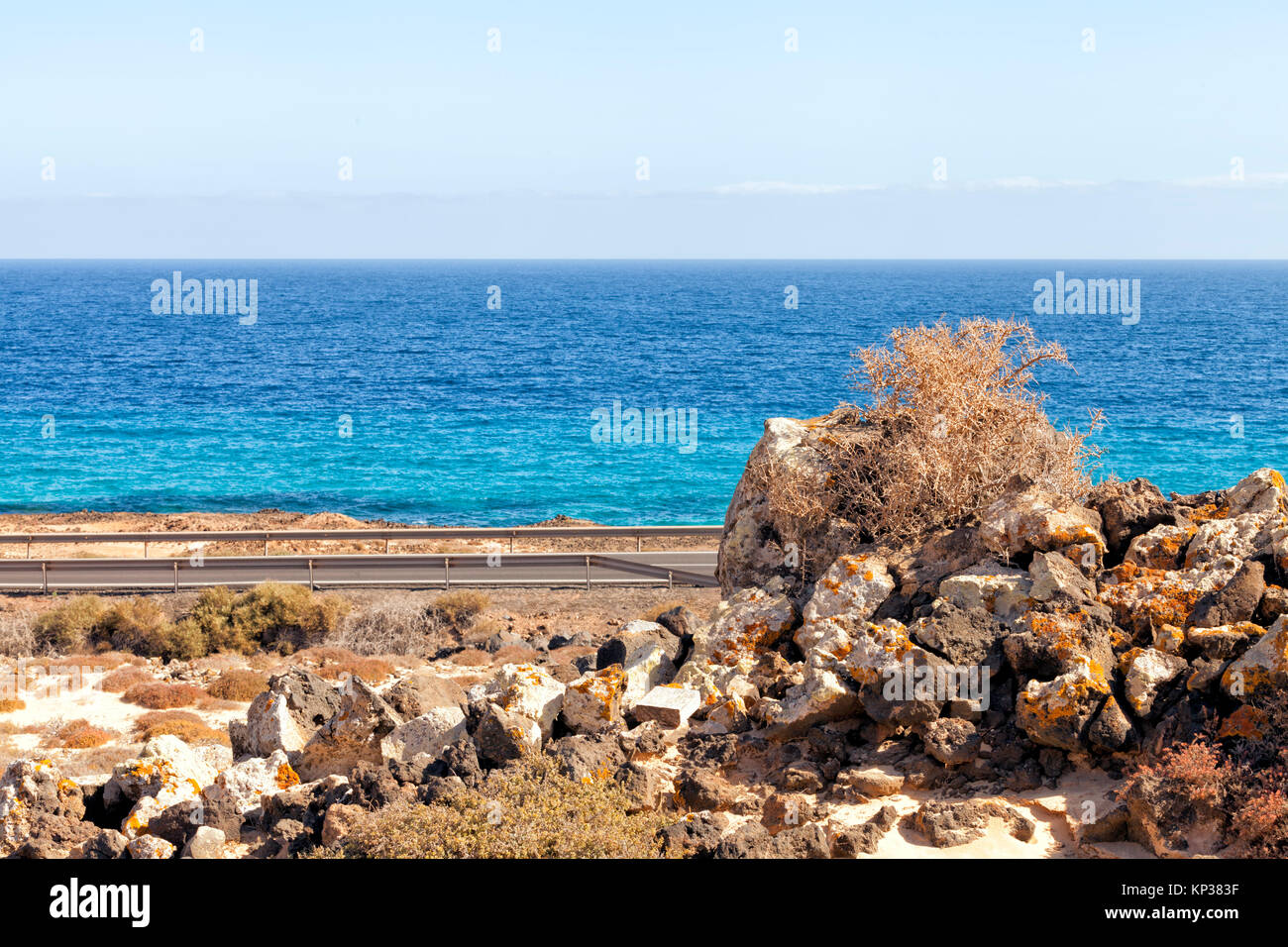 Coastline road, pile of colorful volcanic rocks on edge of desert dune ...