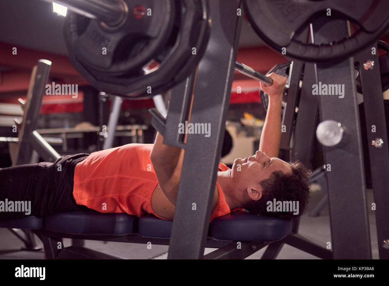 one person, young man, bench press, weight training, side view. Stock Photo