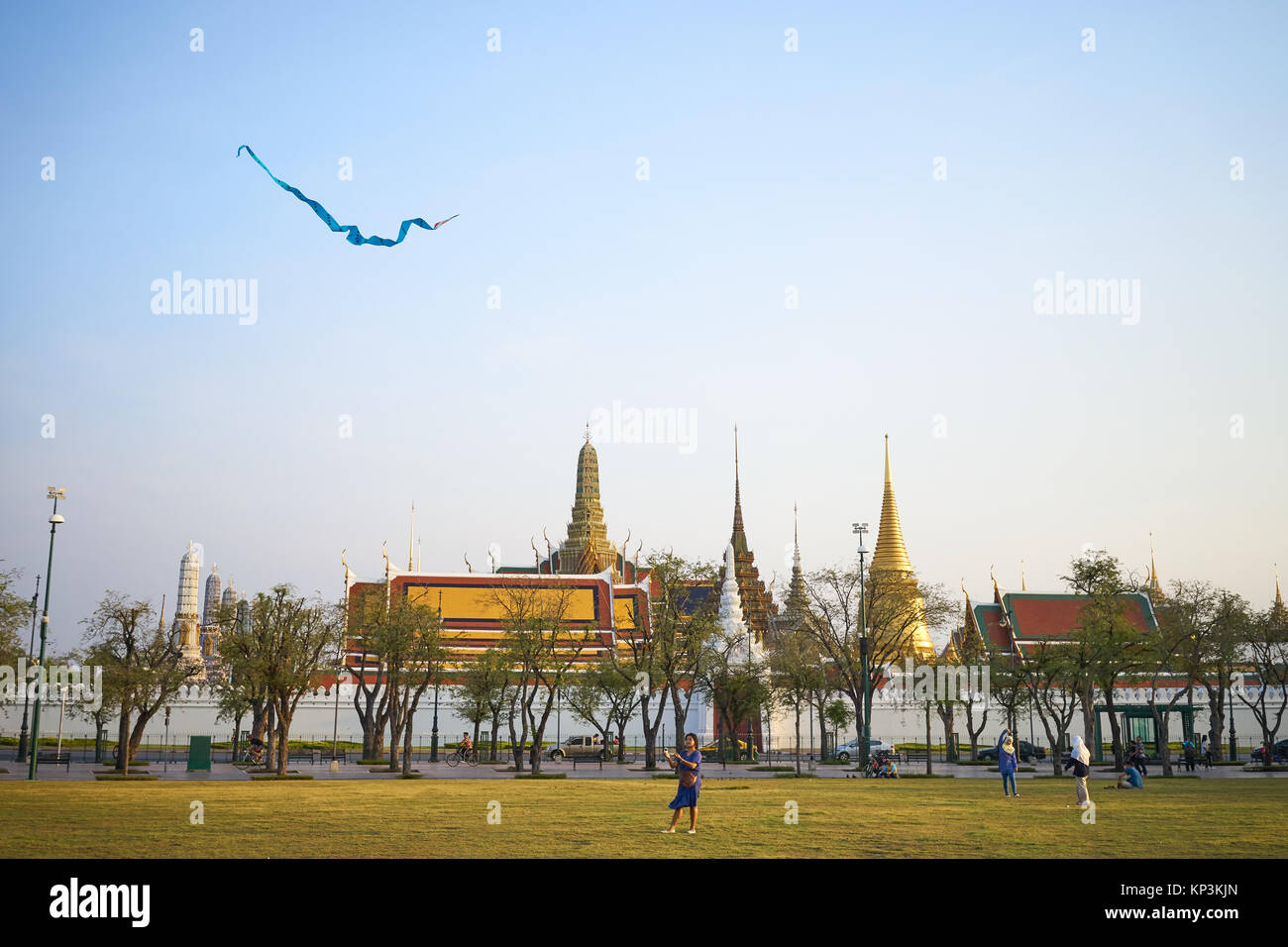 A woman plays with kite in front of the Grand Palace in Bangkok, Thailand Stock Photo