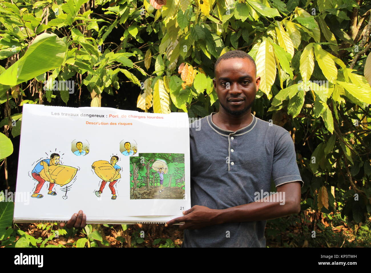 Konan Yaokro, Ivory Coast. 1st Dec, 2017. Serge, an employee of the International Cocoa Initiative, holds up a board explaining the dangers of child labour in the village of Konan Yaokro, Ivory Coast, 1 December 2017. Amangoua plants cocoa on three hectars. Most chocolate in Germany comes from Weste Africa, where more and more children work in the cocoa plantations. Credit: Jürgen Bätz/dpa/Alamy Live News Stock Photo