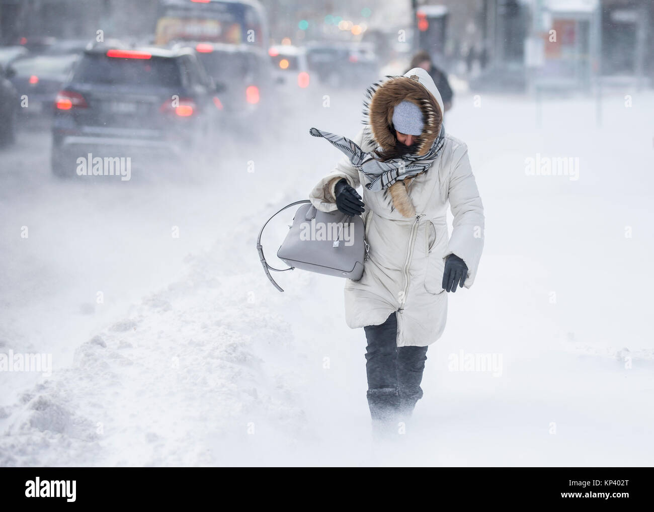 Montreal, Canada. 13th December, 2017. A woman is caught in a sudden gust of wind as she walks on Rene-Levesque boulevard in downtown Montreal, Quebec, Canada, after a snowstorm on Wednesday, December 13, 2017. Credit: Dario Ayala/Alamy Live News Stock Photo