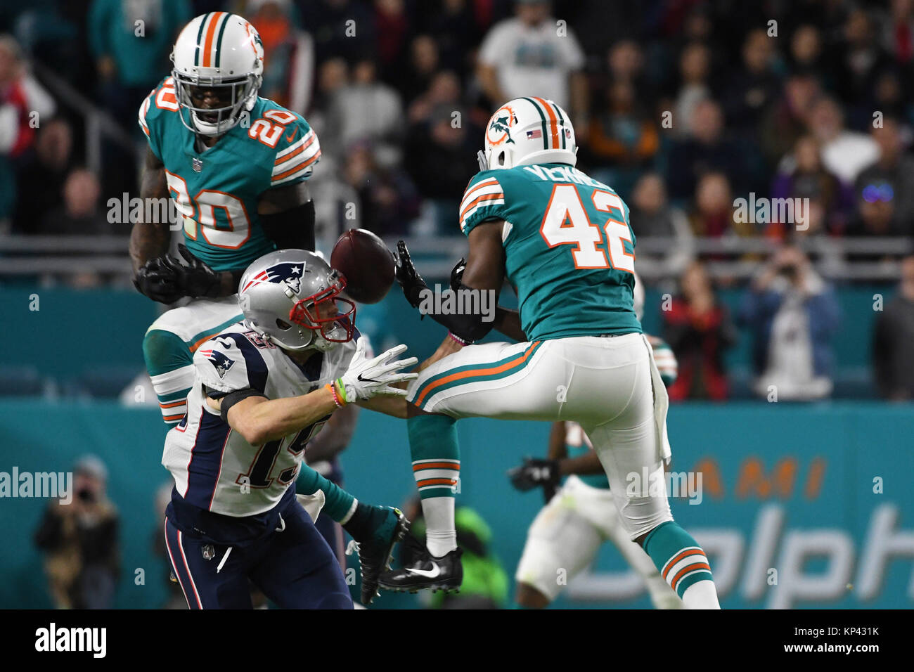 Miami Gardens FL, USA. 11th Dec, 2017. Chris Hogan #15 of New England is defended by Alterraun Verner #42 and Reshad Jones #20 of Miami during the NFL football game between the Miami Dolphins and New England Patriots at Hard Rock Stadium in Miami Gardens FL. The Dolphins defeated the Patriots 27-20. Credit: csm/Alamy Live News Stock Photo