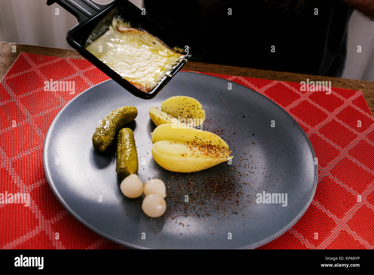 Swiss traditional dish called raclette including steamy potatoes, melted  cheese and pickles eaten at christmas and wintertime Stock Photo - Alamy
