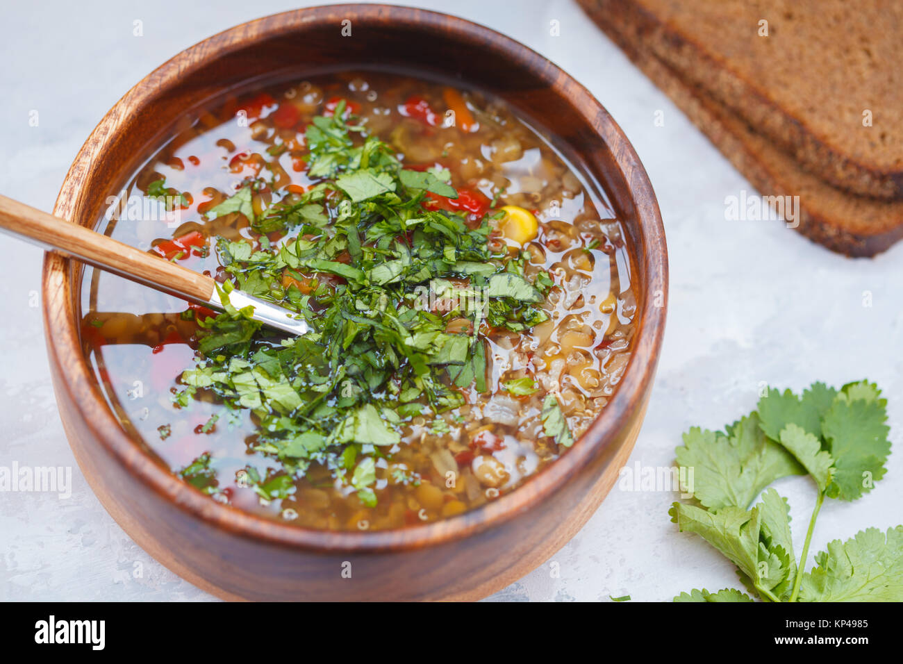 Peruvian soup with quinoa, red rice and lentils in a wooden bowl with