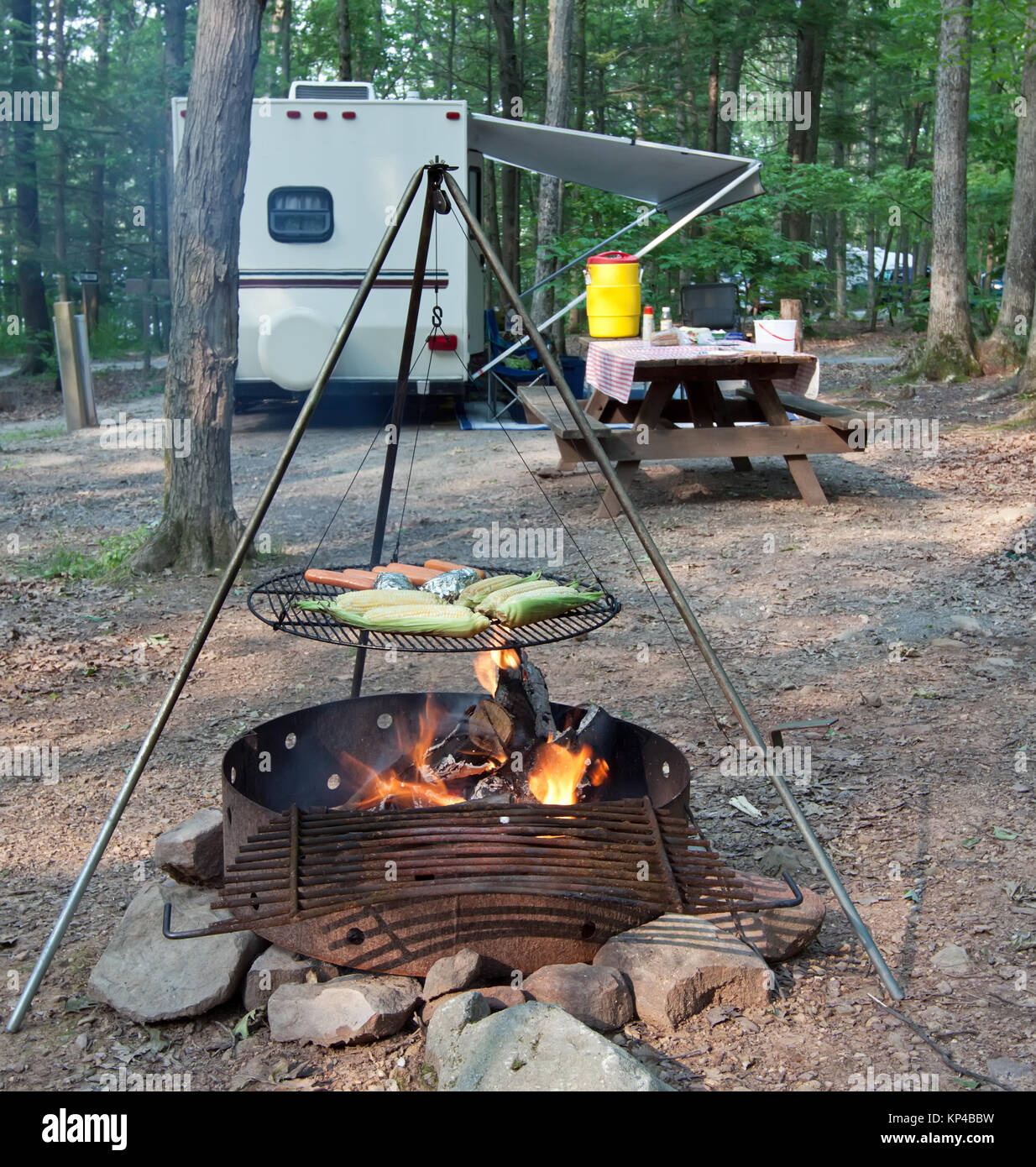 An outdoor grill at a Pennsylvania State Park with a picnic table and camping trailer in the background. Stock Photo