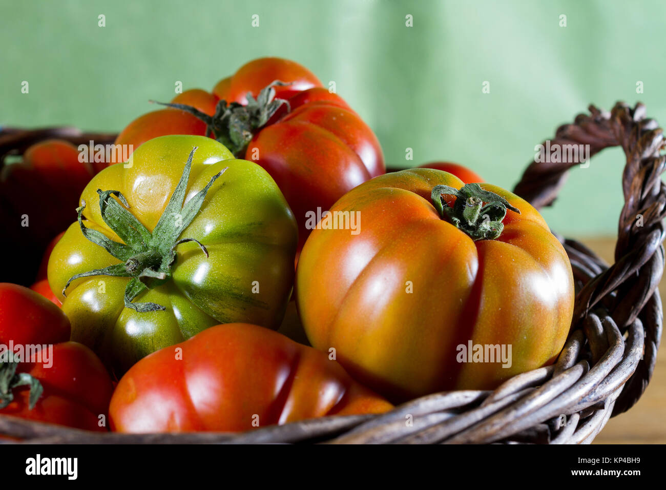 Wicker basket full of delicious red and green tomatoes Stock Photo - Alamy