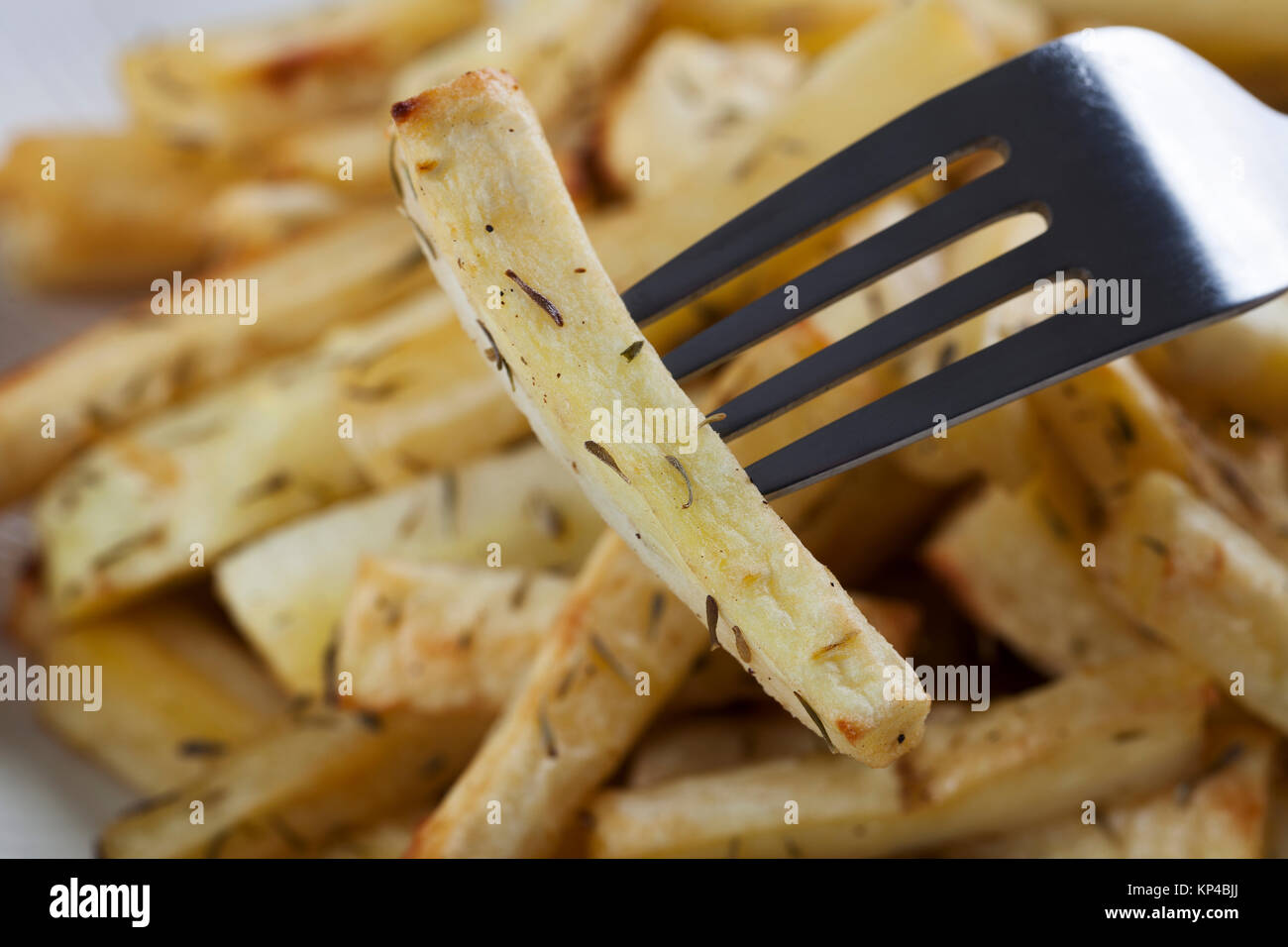 Cut roasted parsnips or potatoes with herbs. Stock Photo