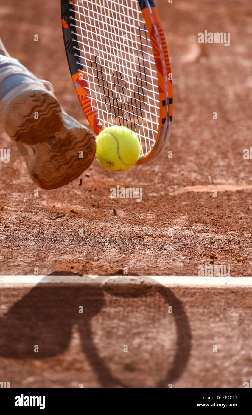 Tennis, a tennis player hits the ball with his foot and his racket