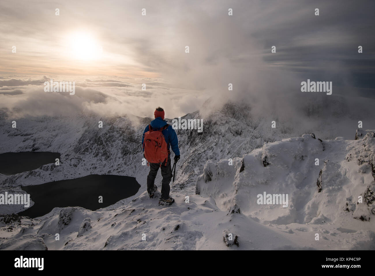 Figure in snowy mountains cape in Snowdonia, mountaineering rucksack, torchlight, Stock Photo