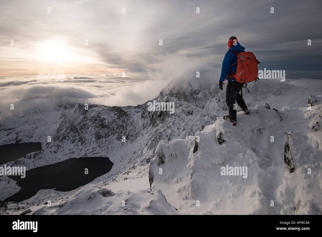 Figure in snowy mountains cape in Snowdonia, mountaineering rucksack, torchlight, Stock Photo