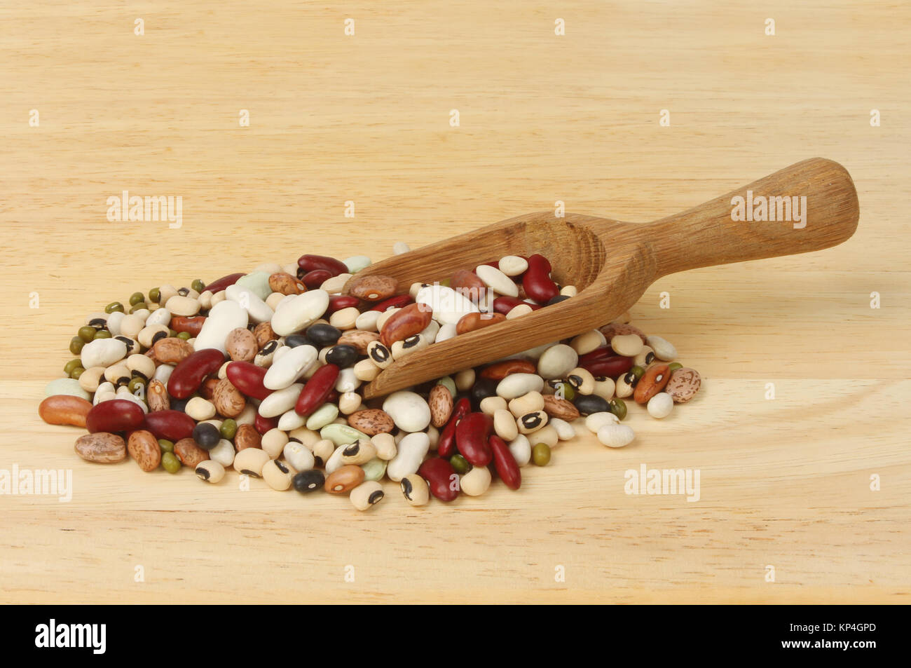Mix of ten dried beans with a wooden scoop on a chopping board Stock Photo
