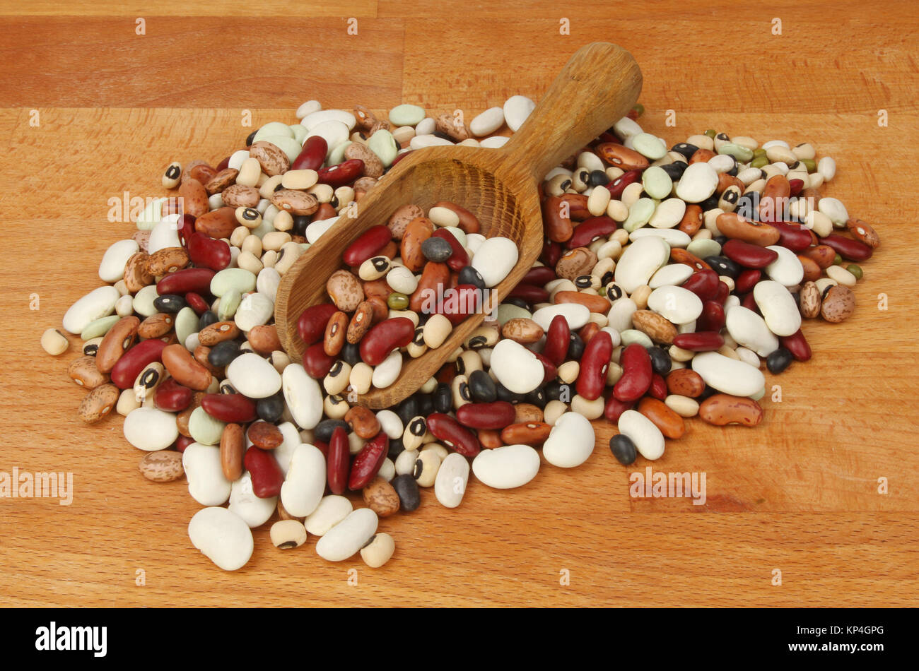Mix if dried beans with a scoop on a wooden chopping board Stock Photo