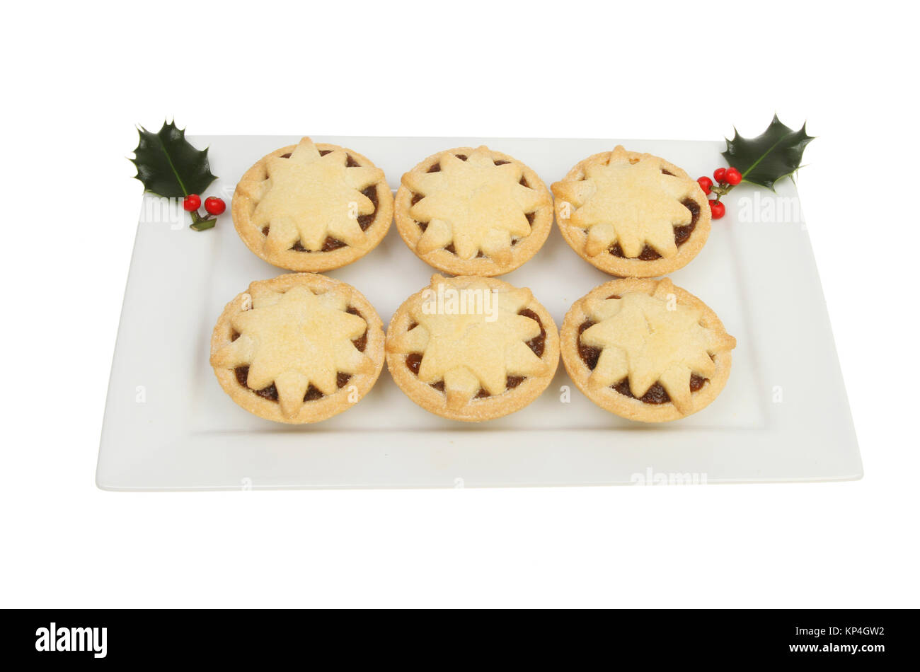 Mince pies decorated with stars on a rectangular plate with holly ...