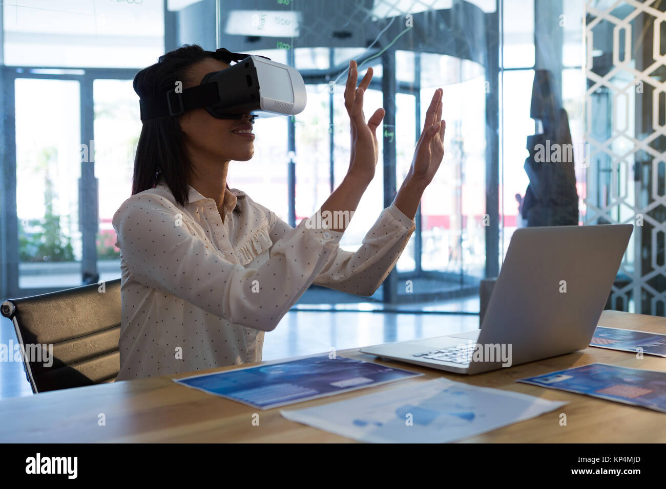 Female executive using virtual reality headset in office Stock Photo ...