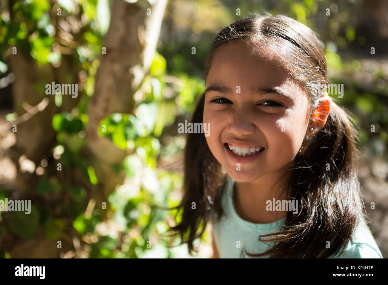 Close-up portrait of happy little girl in the forest on a sunny day ...