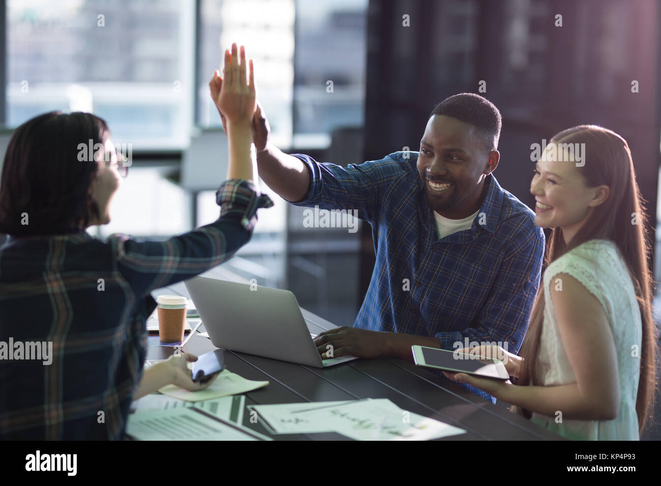 Happy executives giving high five to each other in office Stock Photo ...