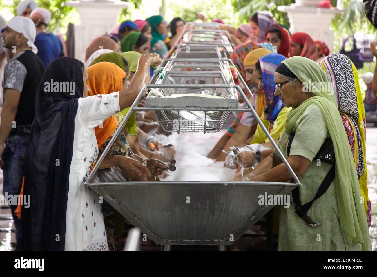 Women cleaning eating utensils. Dining Hall, Harmandir Sahib, Golden