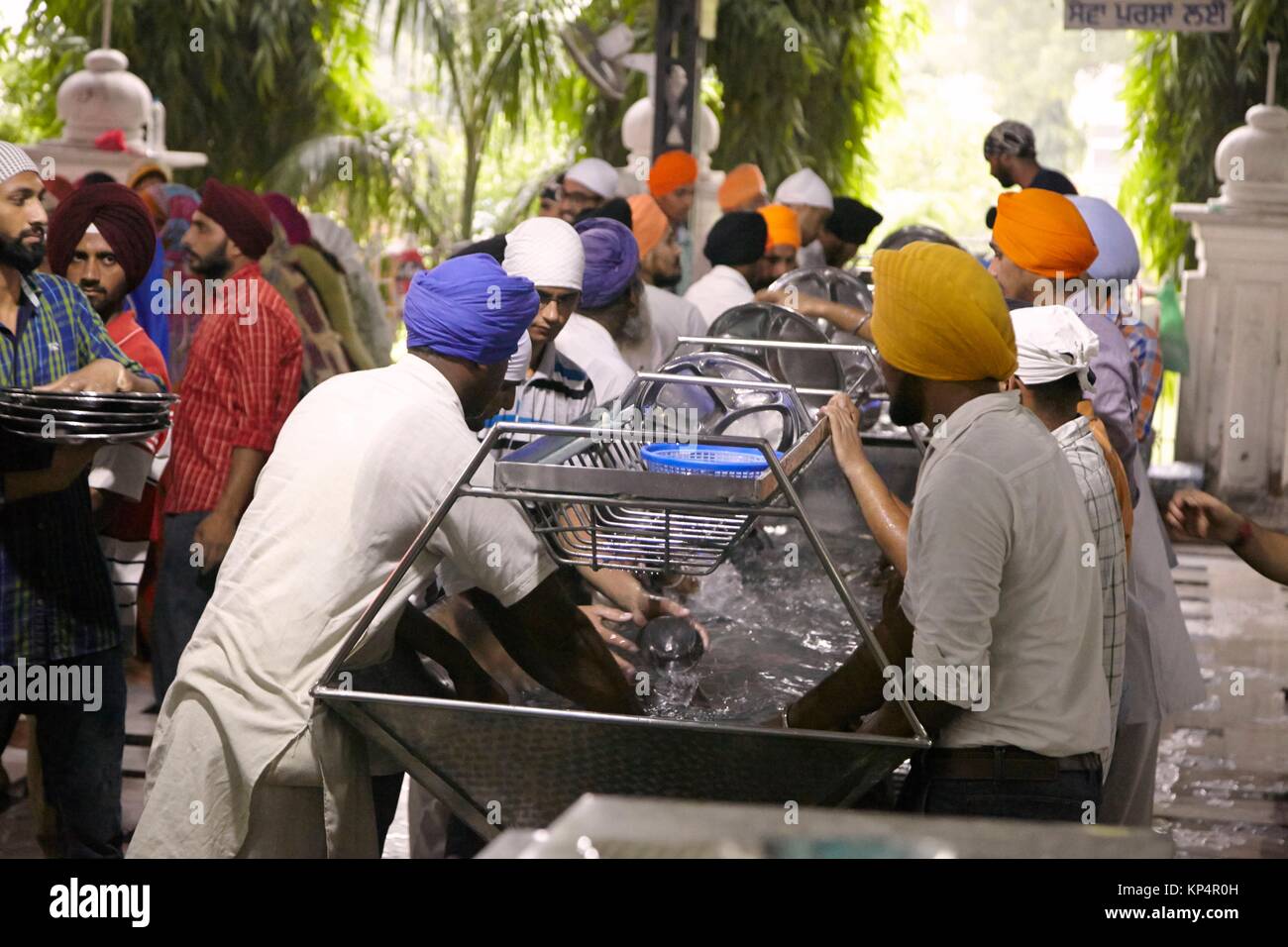 Men cleaning eating utensils. Dining Hall, Harmandir Sahib, Golden Temple, Amritsar, Punyab, India. Stock Photo
