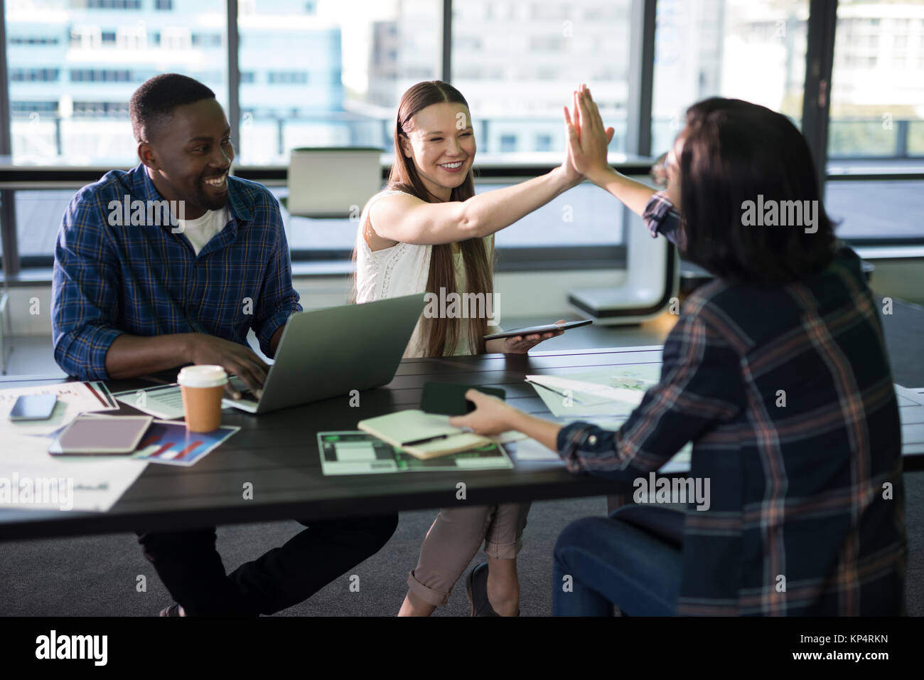 Happy executives giving high five to each other in office Stock Photo ...