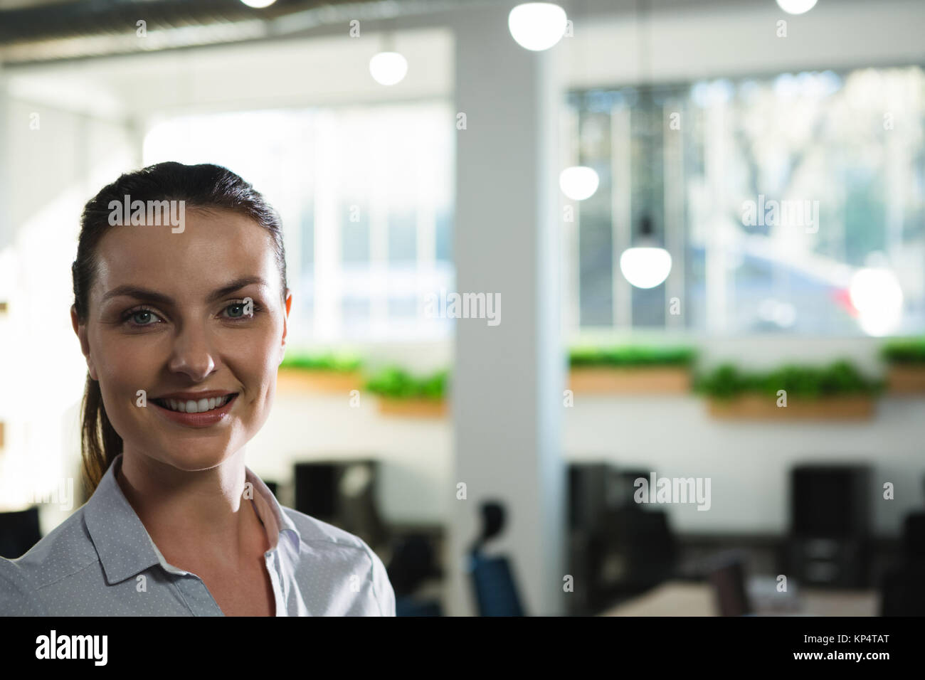 Smiling beautiful female executive looking at camera Stock Photo - Alamy