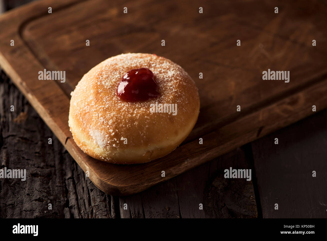 closeup of a sufganiyah, a Jewish donut filled with strawberry jelly