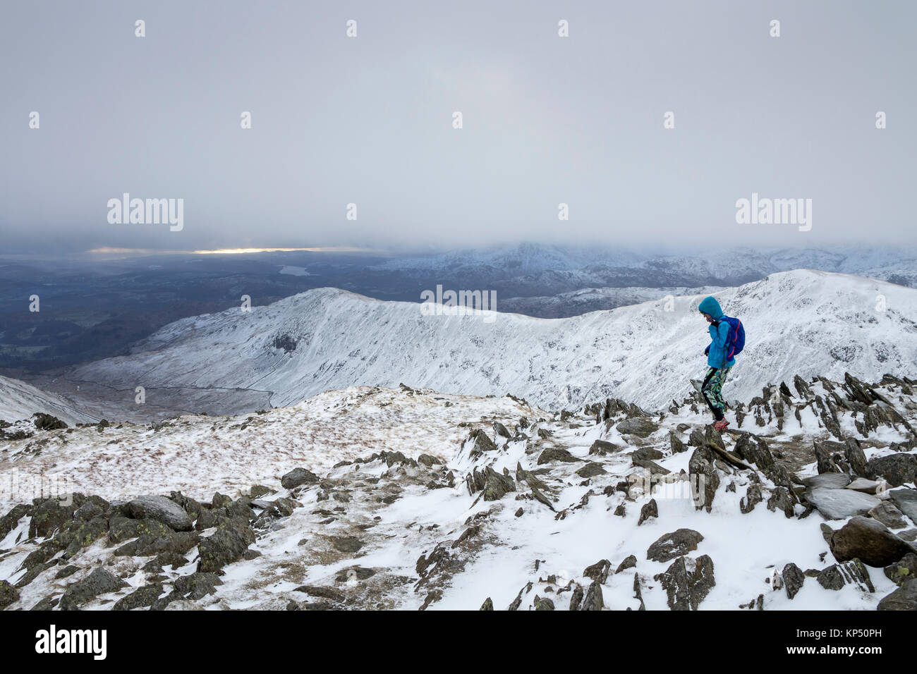 Runner Descending from the Summit of Hart Crag Towards Dove Crag in Winter Conditions, with the View South West Over the Rydal Fells, Lake District, C Stock Photo